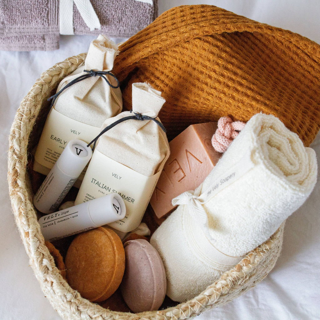 Basket with skincare products, soap, and a towel on a white background