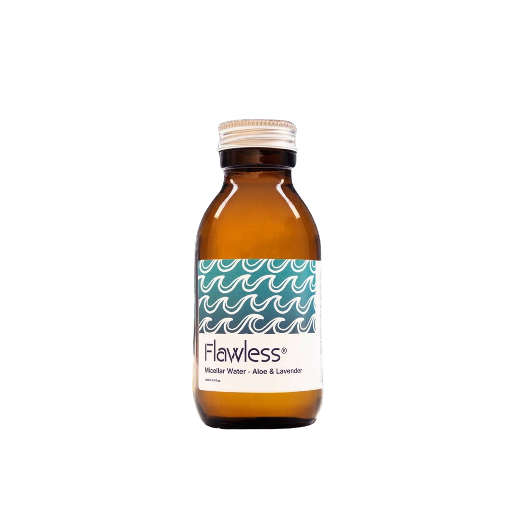 An amber glass bottle of Flawless Micellar Water with Aloe & Lavender, featuring a white label with a teal wave pattern and a silver screw cap, set against a plain white background.